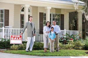 A family with the realtor in front of the house they just had appraised