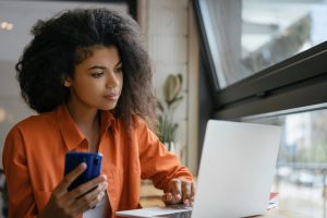 young woman sipping coffee, using laptop for job search
